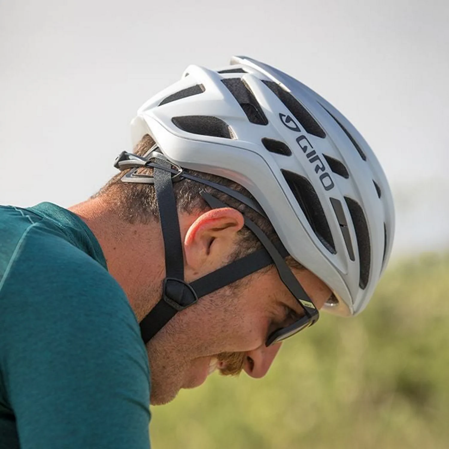Biały kask rowerowy Giro, widok z boku na głowe mężczyzny