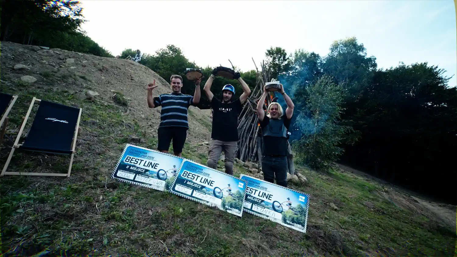 trzech riderów stoi na podium z nagrodami