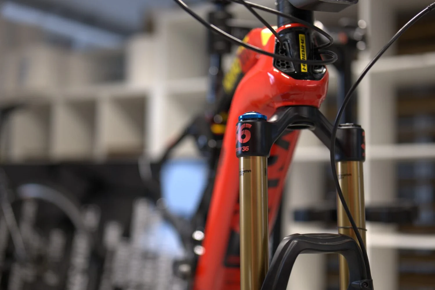 Detal czerwonej ramy roweru Haibike z folią ochronną i widocznym złotym zawieszeniem Fox