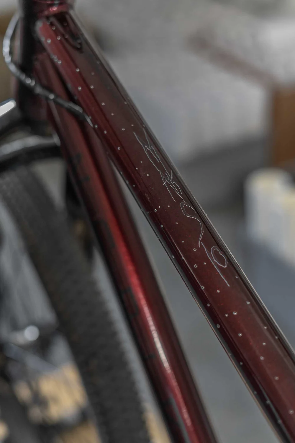 Detal górnej rury roweru z przezroczystą folią ochronną i kroplami deszczu