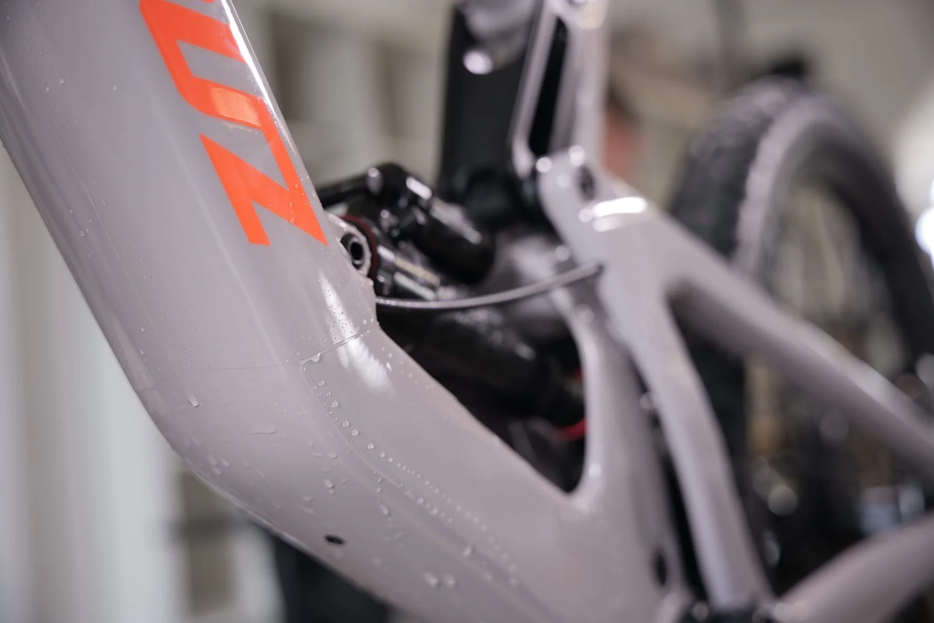 Szara rama roweru z częściowo nałożoną przezroczystą folią ochronną i pomarańczowymi detalami