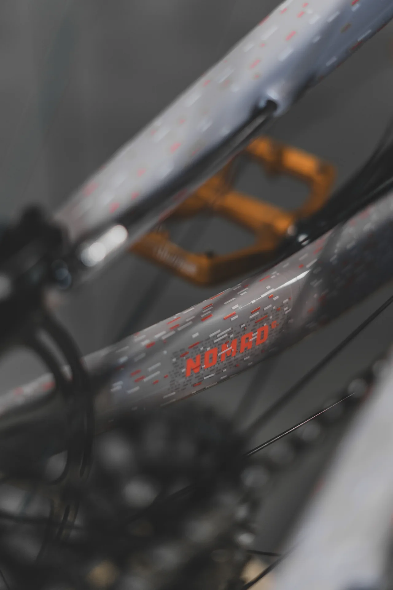 Zbliżenie na ramę roweru z folią ochronną, na której widnieje napis NOMAD