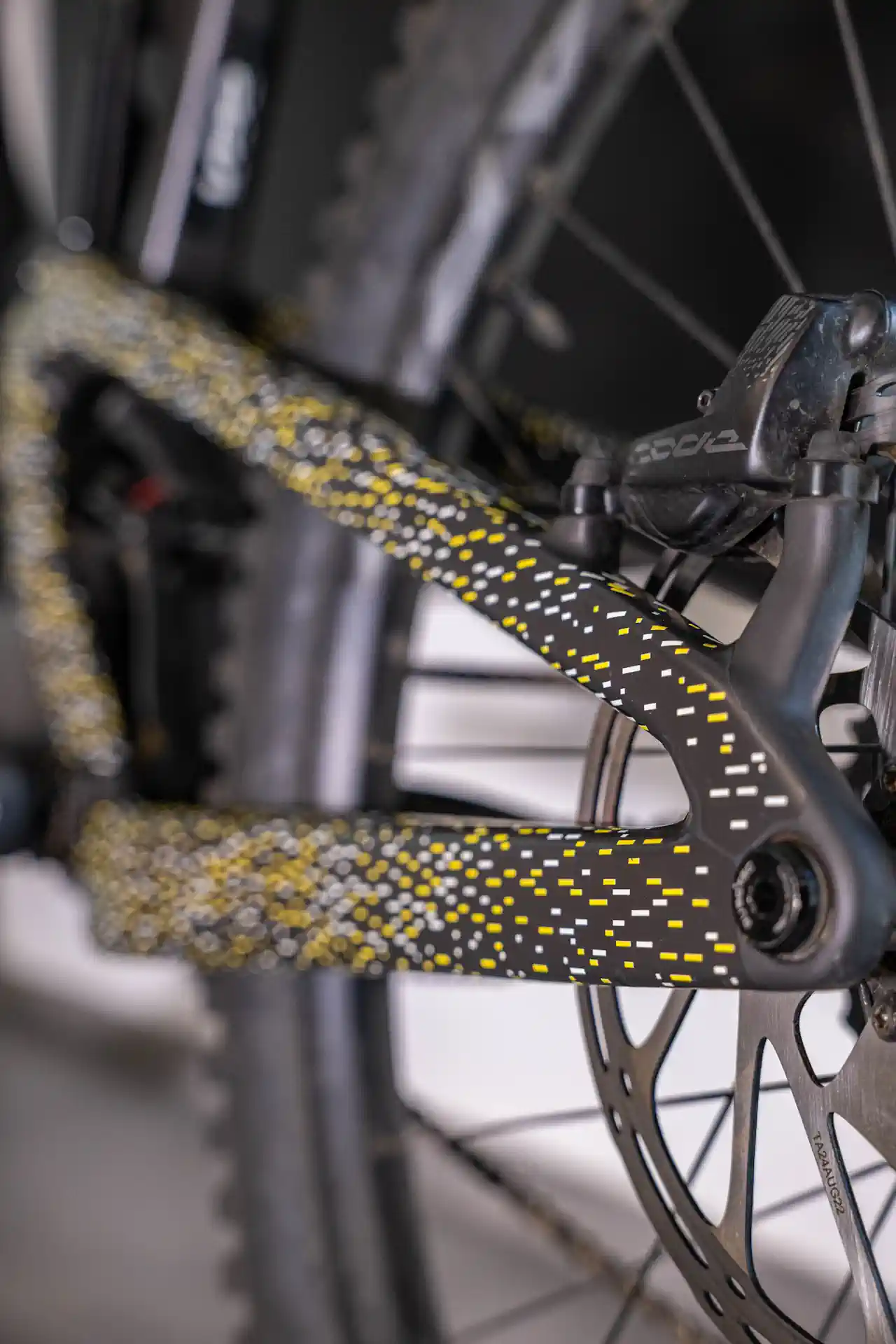 Zbliżenie na żółto-białe wzory folii ochronnej na dolnej ramie roweru