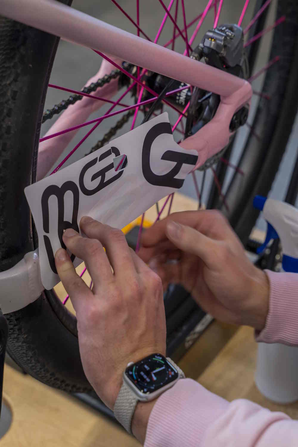 Aplikacja białej folii ochronnej na różową ramę roweru górskiego